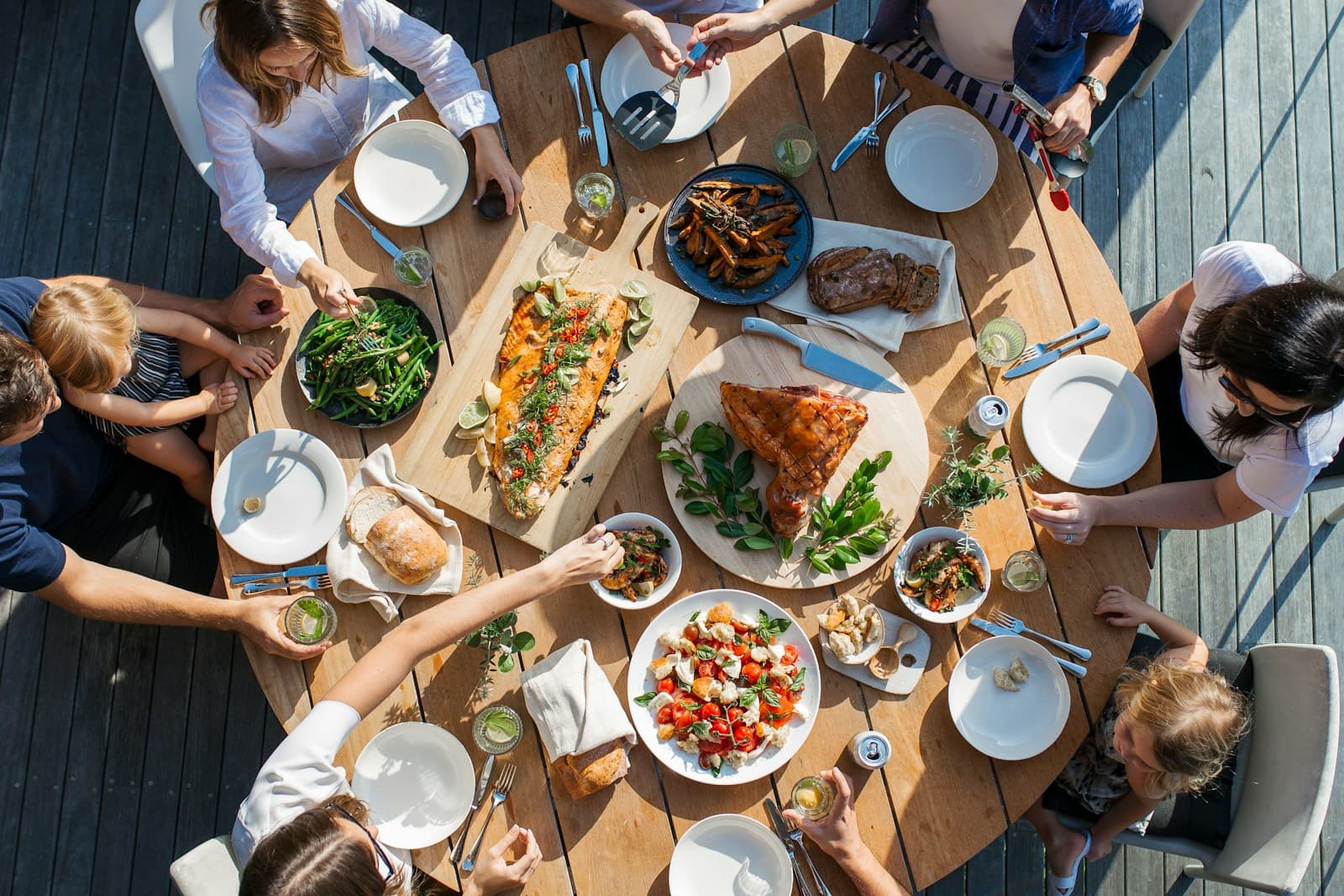 An overhead view of people sharing a meal around an outdoor table.
